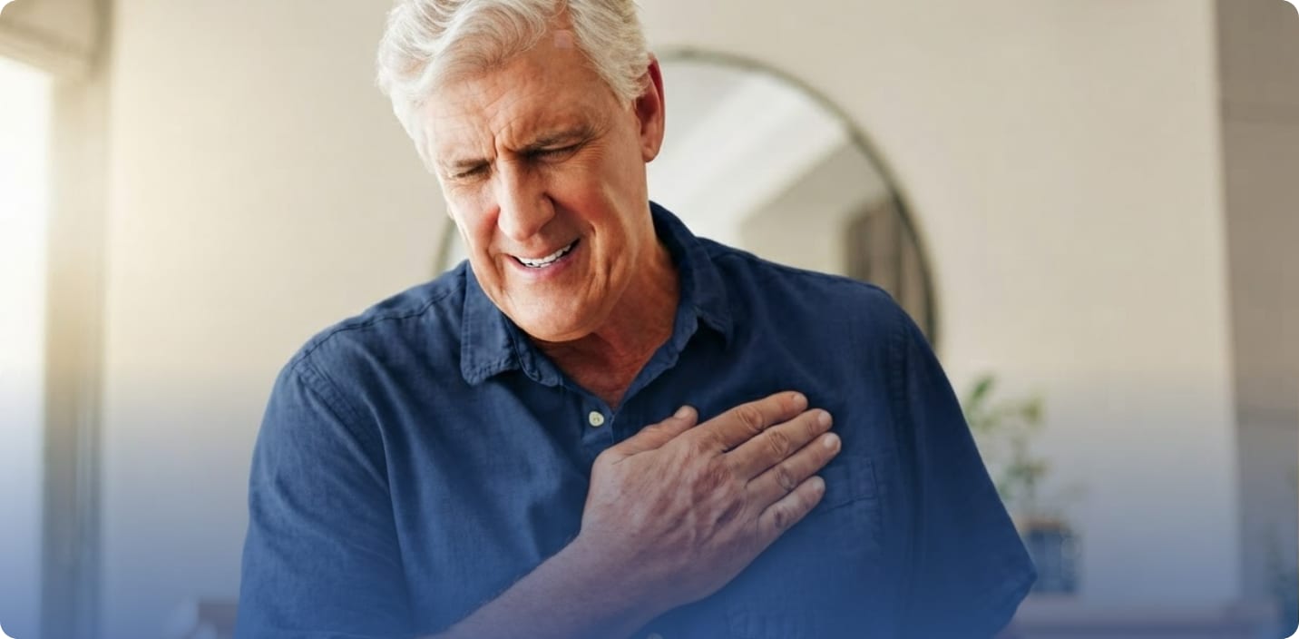 Older gray-haired man pressing a hand to his chest with a pained expression